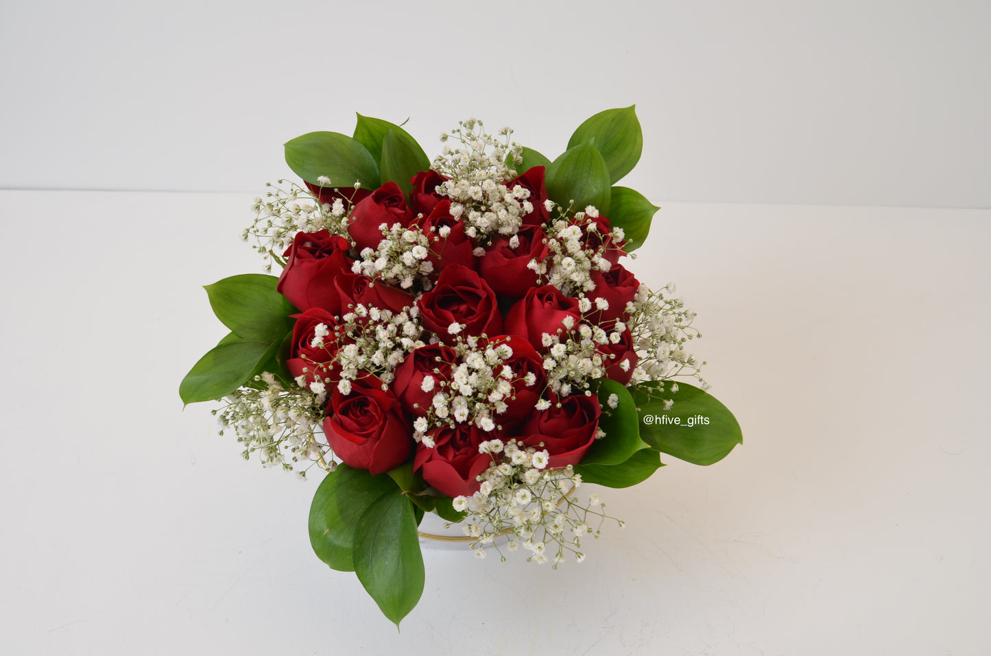 Gorgeous fresh red rose and baby breaths flowers with greenery in a white and black marble and gold box